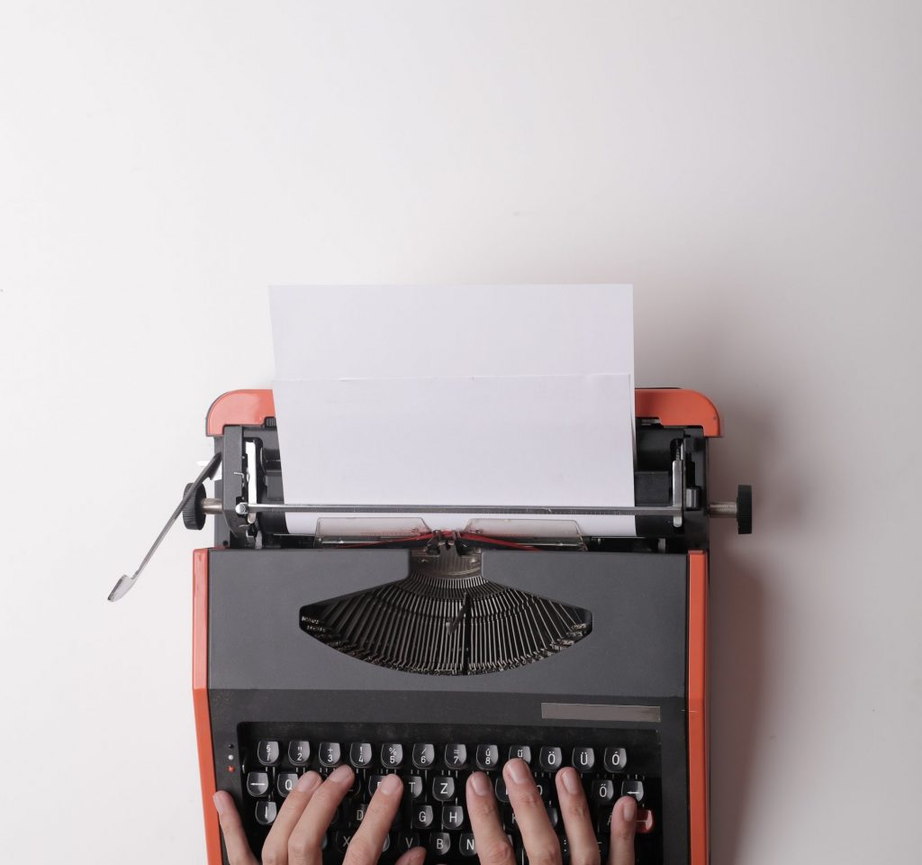 writer-working-on-typewriter-in-office-3808904